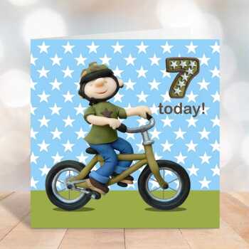Birthday boy age 7 on his bicycle - child's age birthday - designed by Erica Sturla - 15cm square and blank inside, made in the UK