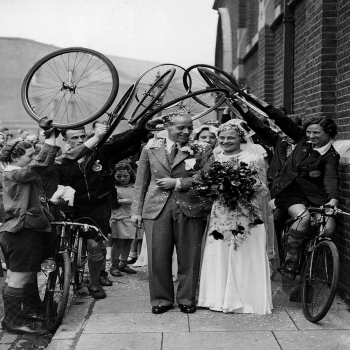 Holy Mackerel cycle salute retro black and white photographic card featuring a vintage image of a wedding couple greeted by cyclists - 12.6 x 17.7cm and blank inside