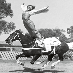 Holy Mackerel equine gymnastics retro black and white photographic card featuring a vintage image of a stunt rider standing on her horse - 12.6 x 17.7cm and blank inside