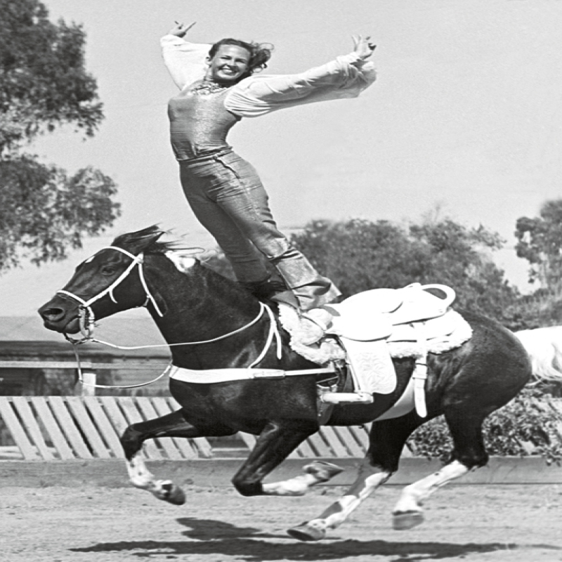Holy Mackerel equine gymnastics retro black and white photographic card featuring a vintage image of a stunt rider standing on her horse - 12.6 x 17.7cm and blank inside