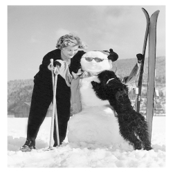 Skier with snowman and poodle