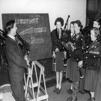 Holy Mackerel bagpipe class retro black and white photographic card featuring a vintage image of children learning to play the pipes - 12.6 x 17.7cm and blank inside