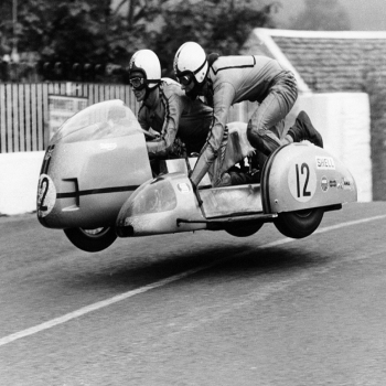 Holy Mackerel TT racers retro black and white photographic card featuring a vintage image of a motorbike leaving the ground - 12.6 x 17.7cm and blank inside