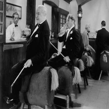 Holy Mackerel drinks on horseback retro black and white photographic card featuring a vintage image of men on model horses - 12.6 x 17.7cm and blank inside