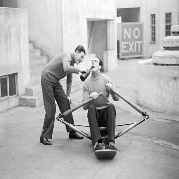 Holy Mackerel a drink for the oarsman retro black and white photographic card featuring a vintage image of a man swigging beer on a rowing machine - 12.6 x 17.7cm and blank inside