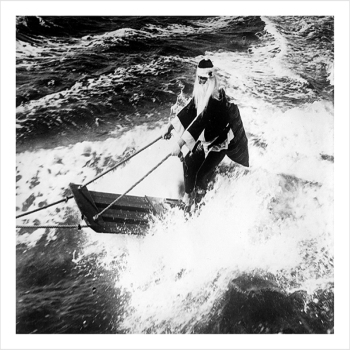 Surfing Santa, a 127 x 175mm Alternative Image winter themed Christmas card featuring a vintage black and white photo, message inside says Happy Christmas